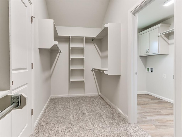 walk in closet featuring light colored carpet