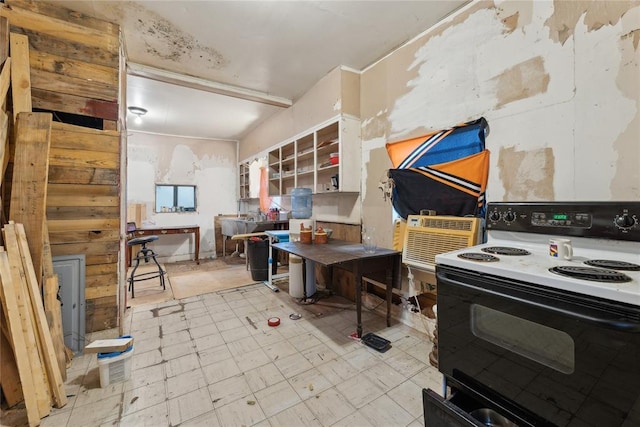 kitchen with electric range, white cabinetry, and a wall mounted AC