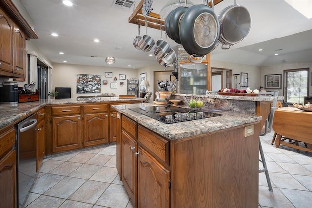 kitchen with black electric stovetop, stainless steel dishwasher, kitchen peninsula, a breakfast bar, and light tile patterned floors