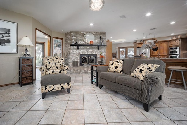 tiled living room featuring a brick fireplace