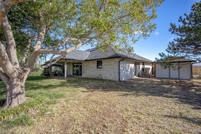 back of property with a shed and a yard