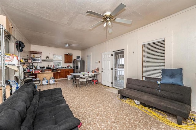 living room with ceiling fan and a textured ceiling