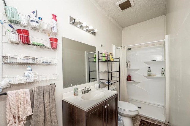 bathroom with curtained shower, vanity, a textured ceiling, and toilet