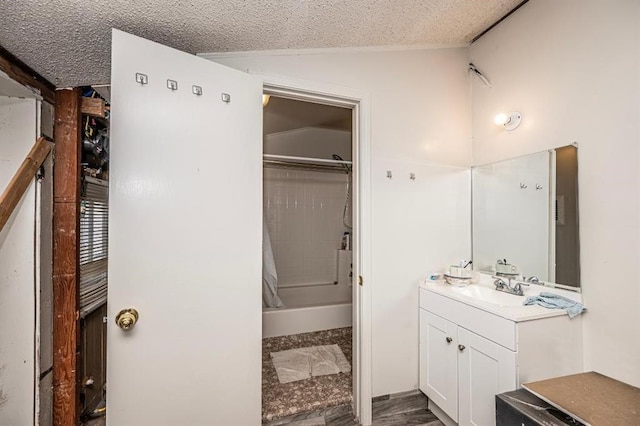 bathroom featuring vanity, lofted ceiling, a textured ceiling, and walk in shower