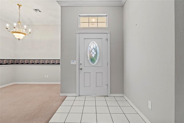 carpeted foyer featuring crown molding and a chandelier