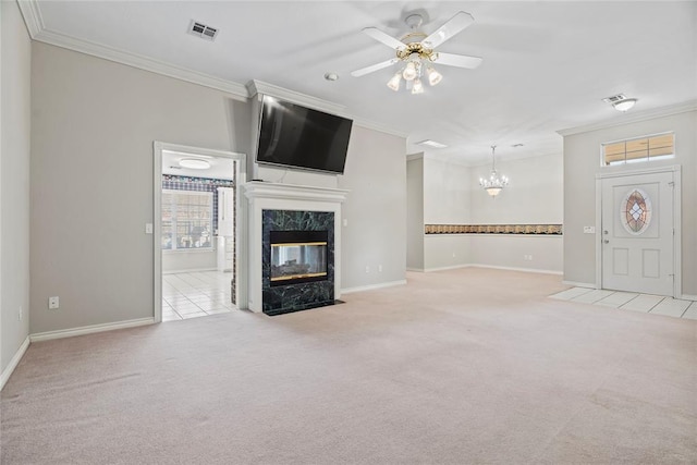 unfurnished living room with ceiling fan with notable chandelier, a premium fireplace, light carpet, and ornamental molding