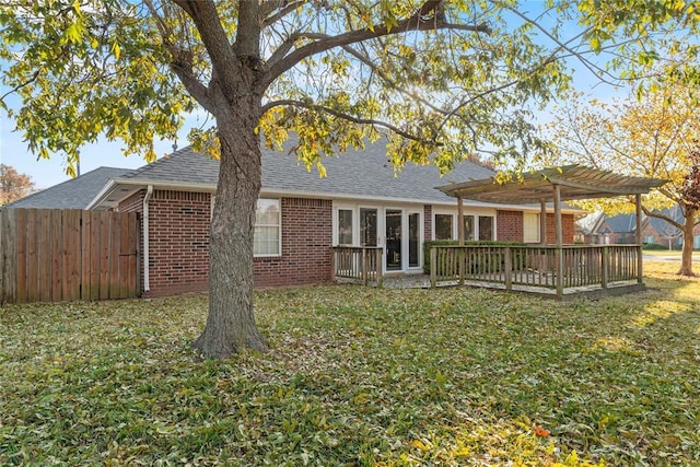 rear view of house with a pergola, a yard, and a deck