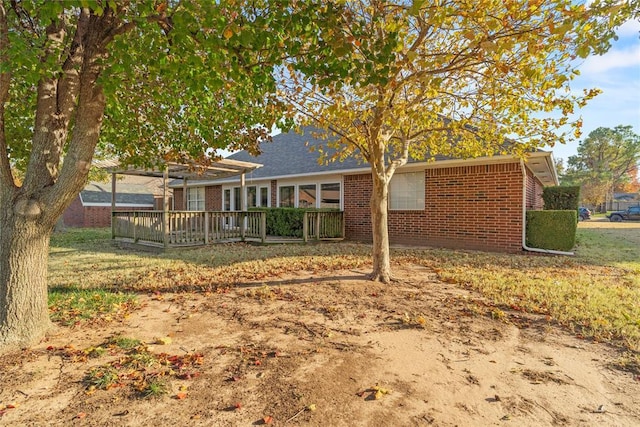 rear view of house featuring a lawn and a deck