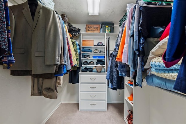 walk in closet with light colored carpet