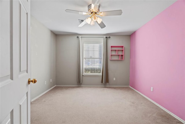 empty room featuring ceiling fan and light carpet