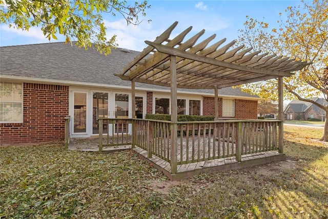 rear view of house featuring a pergola, a wooden deck, and a yard