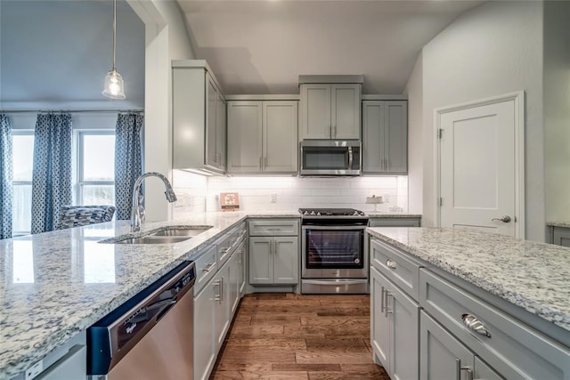 kitchen featuring sink, dark hardwood / wood-style floors, gray cabinets, decorative light fixtures, and stainless steel appliances