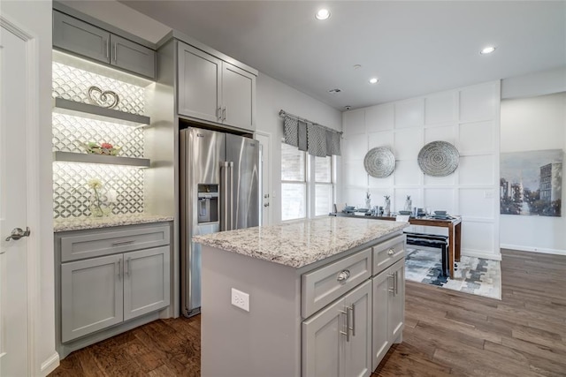 kitchen with stainless steel fridge, dark hardwood / wood-style flooring, a center island, and gray cabinetry