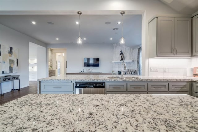 kitchen featuring dishwasher, sink, light stone counters, decorative light fixtures, and gray cabinets