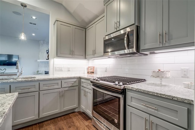 kitchen with sink, stainless steel appliances, tasteful backsplash, dark hardwood / wood-style flooring, and gray cabinets