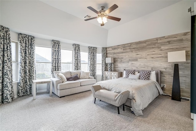 bedroom with ceiling fan, carpet floors, and wooden walls