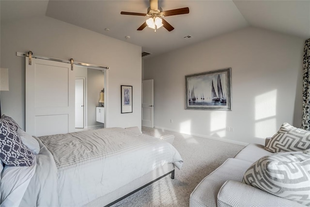 carpeted bedroom featuring a barn door, ensuite bathroom, vaulted ceiling, and ceiling fan