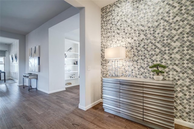 hall featuring built in shelves, hardwood / wood-style floors, and tile walls