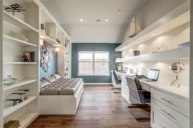 office area with hardwood / wood-style floors, built in desk, and vaulted ceiling