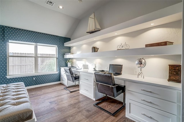 office featuring built in desk, vaulted ceiling, and light wood-type flooring