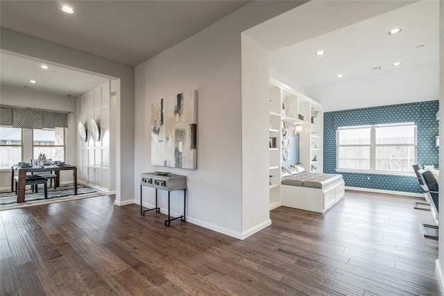 interior space featuring built in features, dark wood-type flooring, and baseboard heating