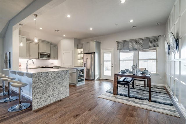 kitchen with sink, hanging light fixtures, dark hardwood / wood-style floors, gray cabinets, and stainless steel appliances