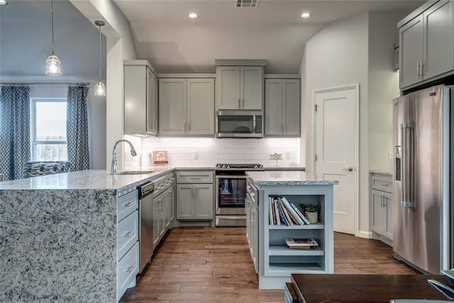 kitchen featuring lofted ceiling, sink, dark hardwood / wood-style floors, kitchen peninsula, and stainless steel appliances