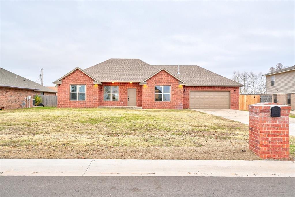 single story home with a garage and a front lawn