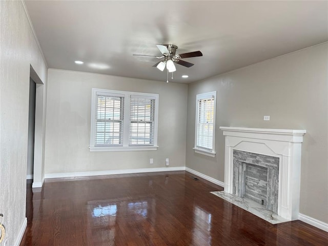 unfurnished living room featuring plenty of natural light, ceiling fan, and dark wood-type flooring