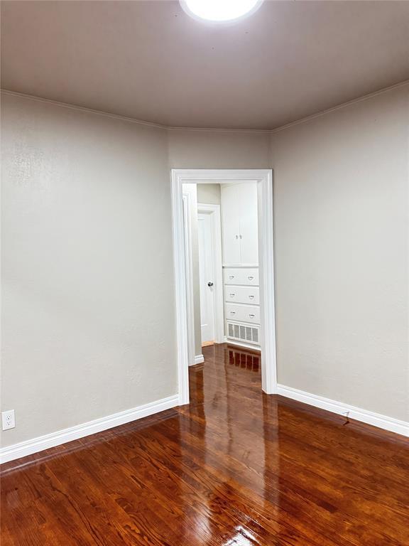 spare room with dark hardwood / wood-style flooring and crown molding