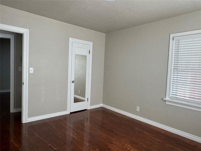 unfurnished bedroom featuring dark hardwood / wood-style flooring and a textured ceiling