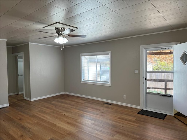 interior space with a wealth of natural light, wood-type flooring, and ornamental molding