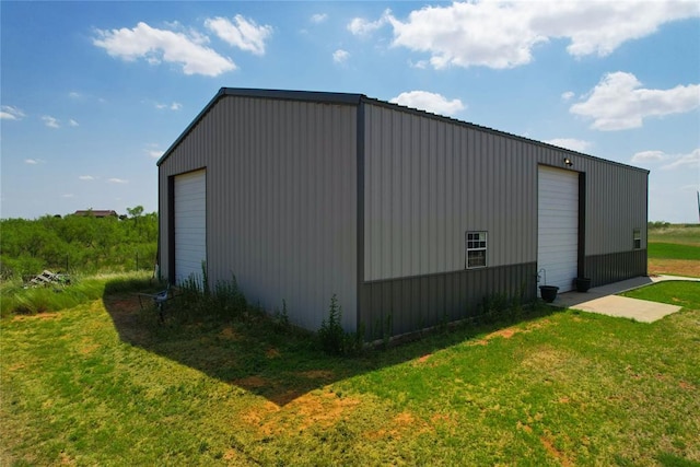 view of outdoor structure with a garage and a lawn