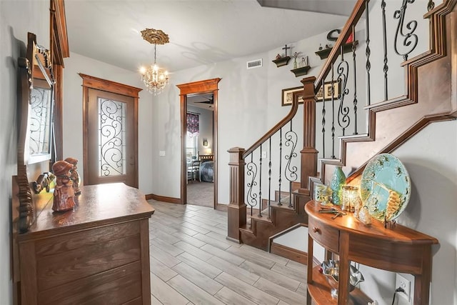 foyer featuring light wood-type flooring and a notable chandelier