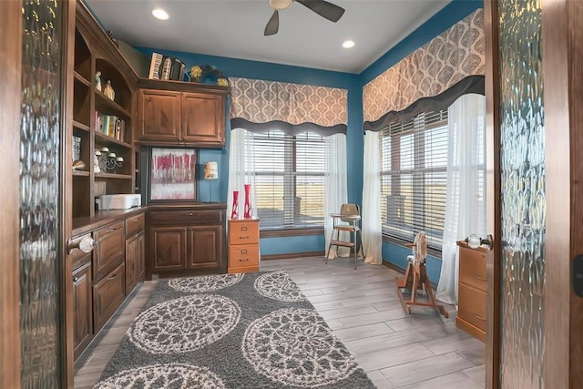 home office with ceiling fan and light hardwood / wood-style flooring