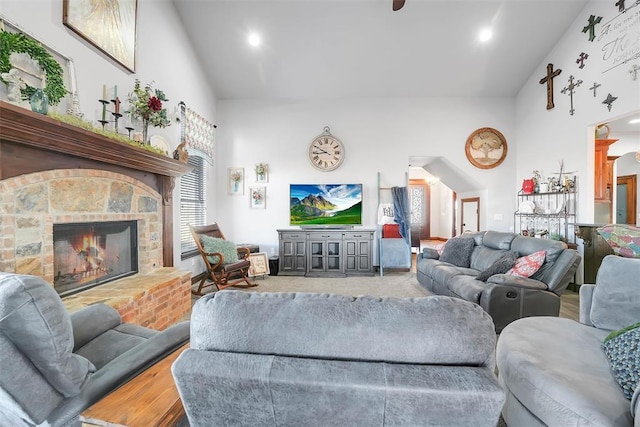 living room with a fireplace and high vaulted ceiling