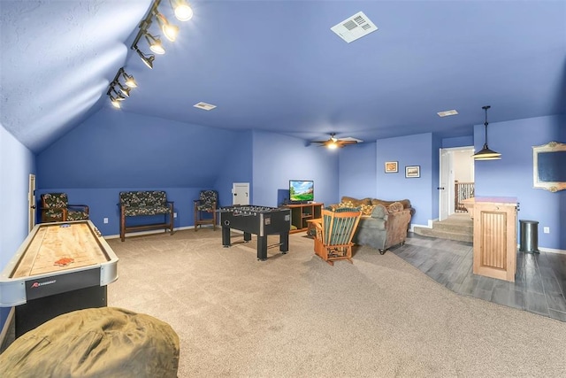 rec room featuring carpet, ceiling fan, vaulted ceiling, and track lighting