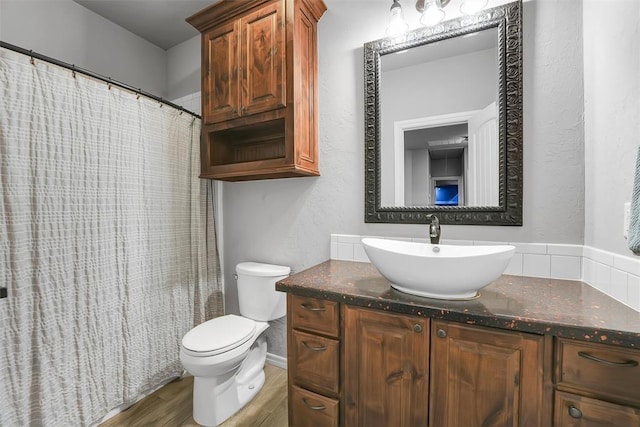 bathroom with hardwood / wood-style floors, vanity, and toilet