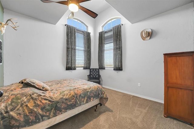 carpeted bedroom with ceiling fan and vaulted ceiling