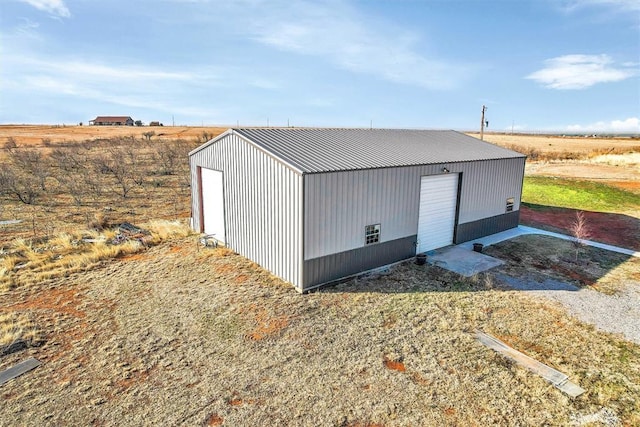 view of outbuilding featuring a rural view and a garage