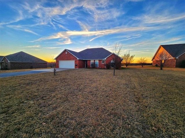 ranch-style home featuring concrete driveway, an attached garage, brick siding, and a front yard
