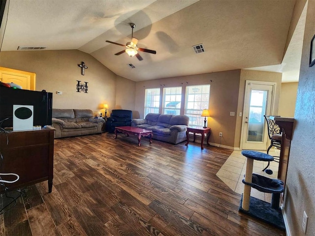 living room featuring visible vents, vaulted ceiling, wood finished floors, and a ceiling fan