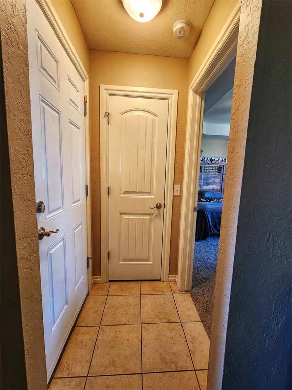 entryway featuring a textured wall and light tile patterned floors