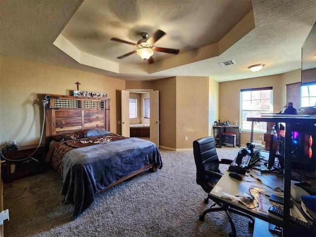 bedroom with a textured ceiling, carpet floors, a raised ceiling, baseboards, and visible vents
