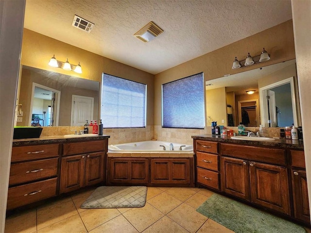 full bath featuring tile patterned flooring, a sink, visible vents, and a textured ceiling