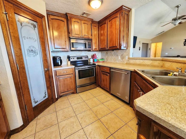 kitchen featuring a sink, light tile patterned flooring, visible vents, decorative backsplash, and appliances with stainless steel finishes