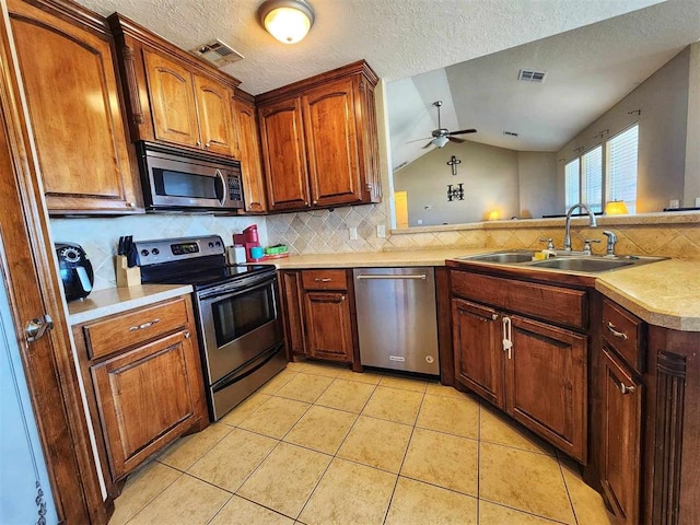kitchen featuring visible vents, decorative backsplash, stainless steel appliances, and a sink