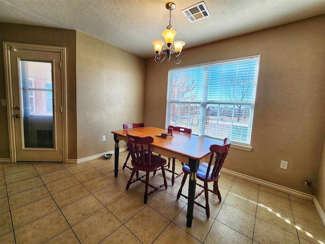 dining area featuring baseboards, visible vents, a chandelier, and light tile patterned floors