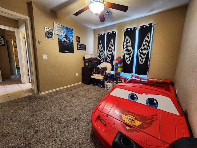 bedroom featuring a textured wall, a ceiling fan, visible vents, and carpet