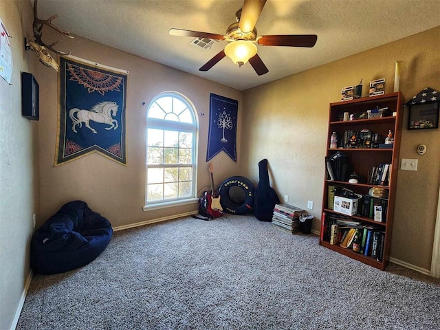 misc room featuring carpet, a ceiling fan, baseboards, and a textured ceiling